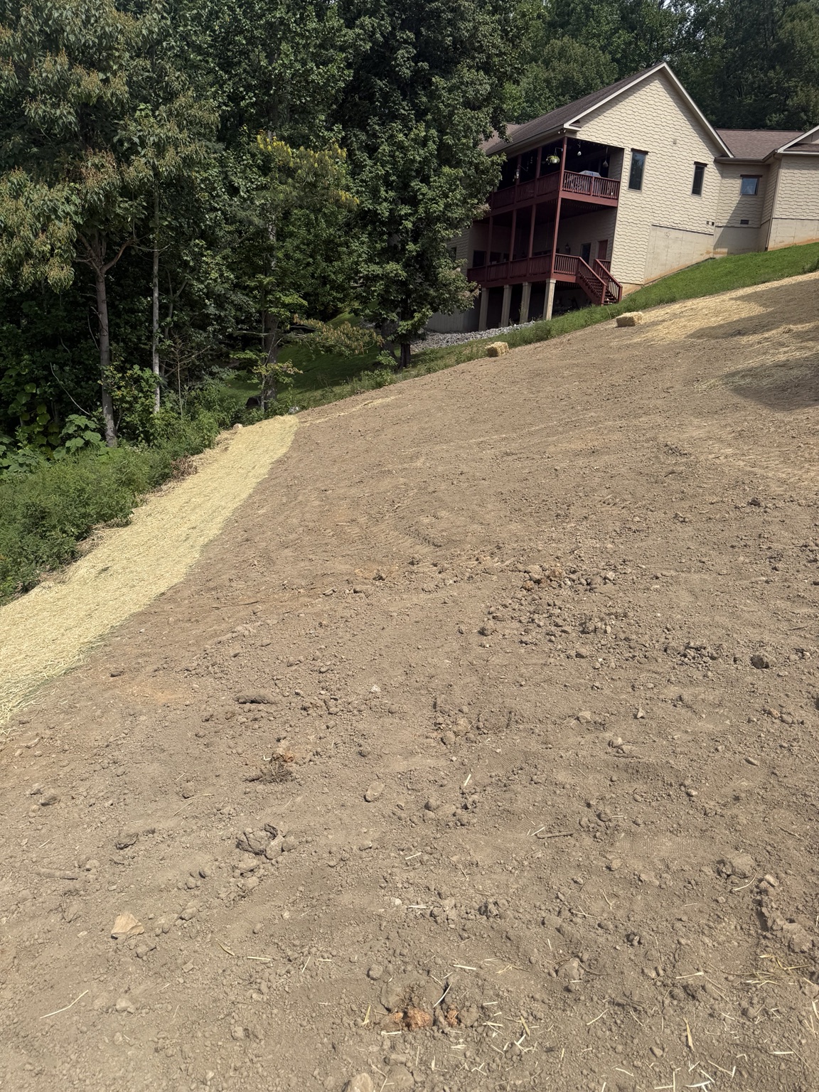 Large graded area beside residential buildings