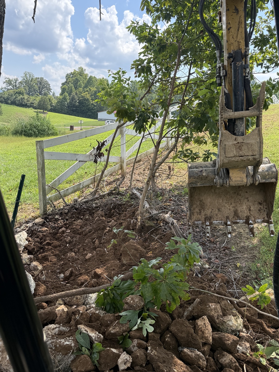 Excavator performing clearing and excavation work